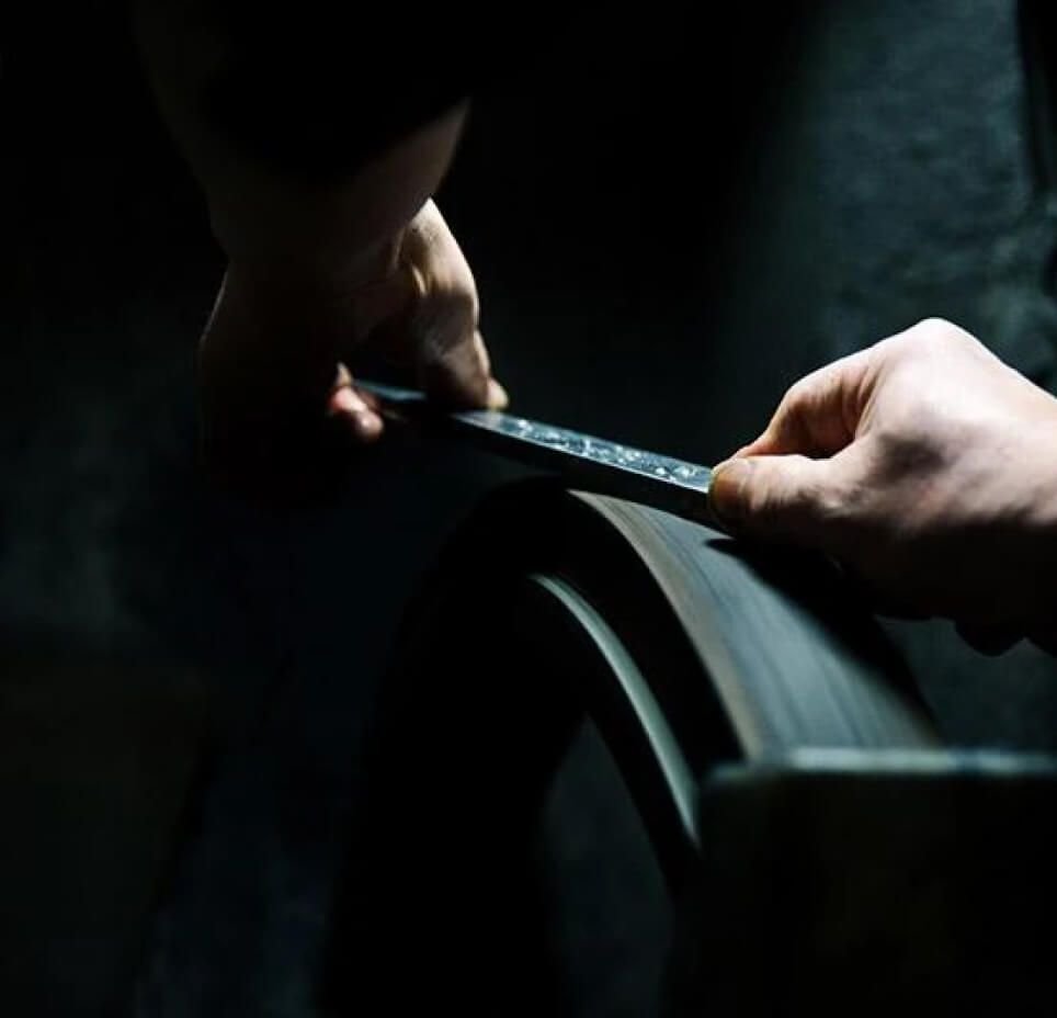 Hands sharpening a Matsato knife blade on a whetstone